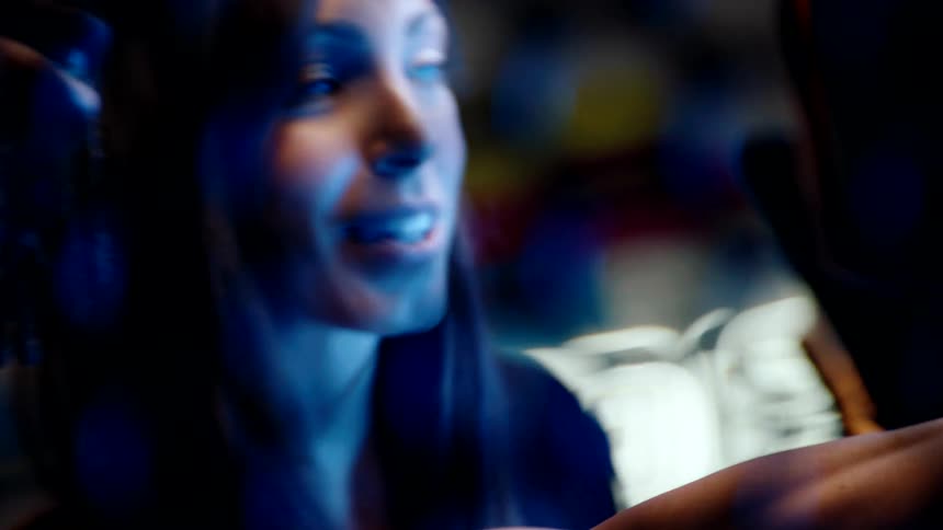 A woman points at the arcade cabinet