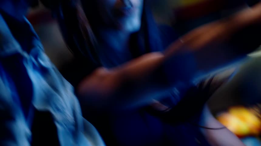 A woman and a man have fun in an arcade as the woman smiles and points to an item