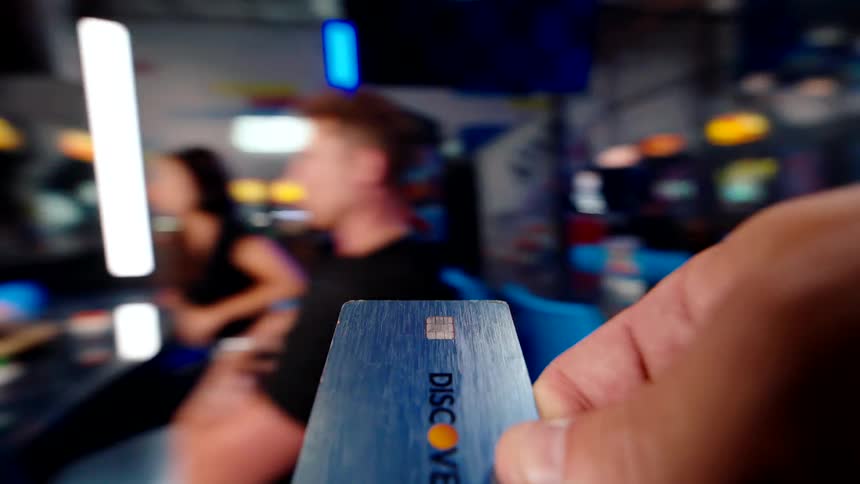 A person pays in the arcade with a credit card