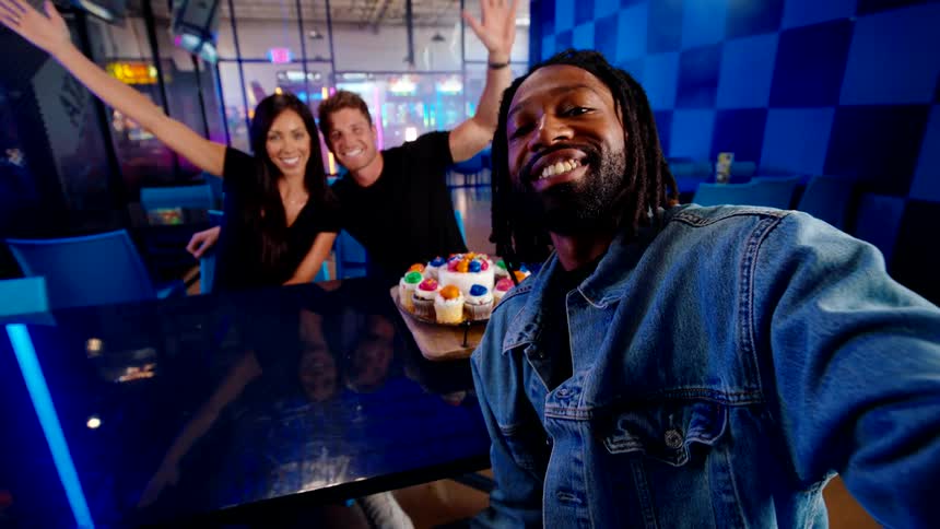 Group of friends sitting at a table taking a selfie happily