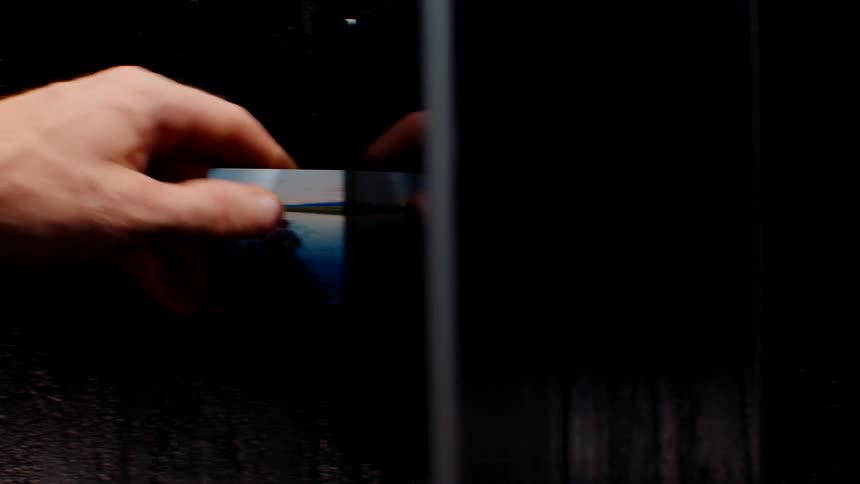A person puts their card into the door