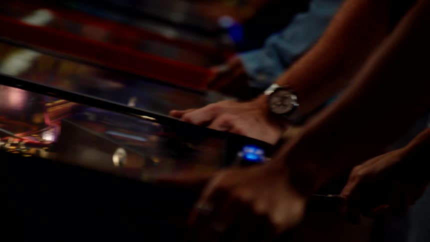 Arms of people playing classic game on a machine
