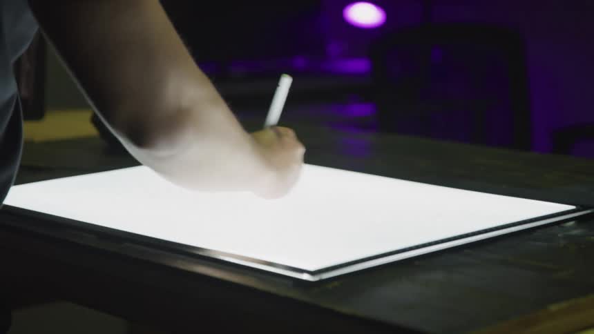 A person is sketching on the drawing tablet