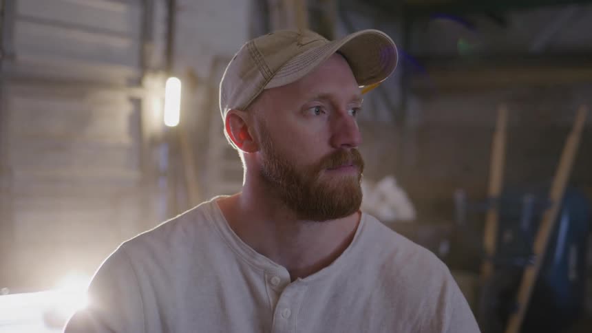 A man is standing in his garage and looking to the distance