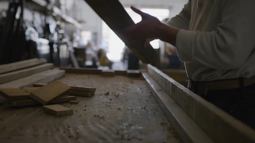 A man places some blocks of wood on a table
