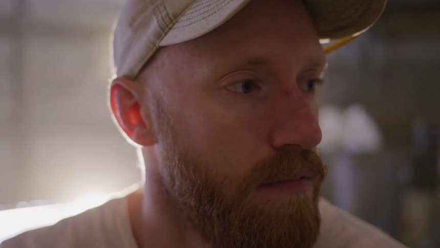 A man is looking around his garage deep in thought