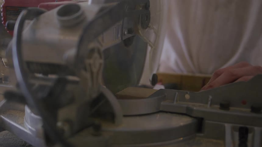 The carpenter is cutting wood with a table saw