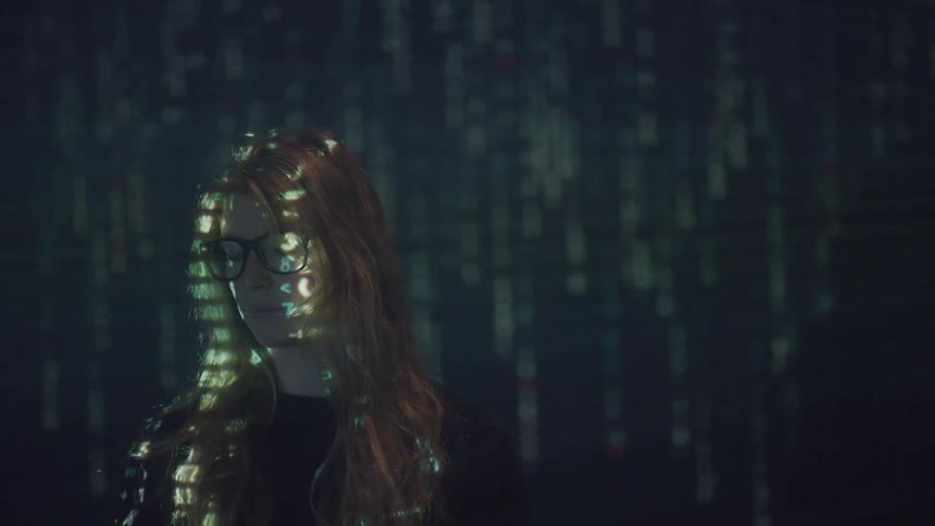 A woman stands near a backdrop with digital special effects