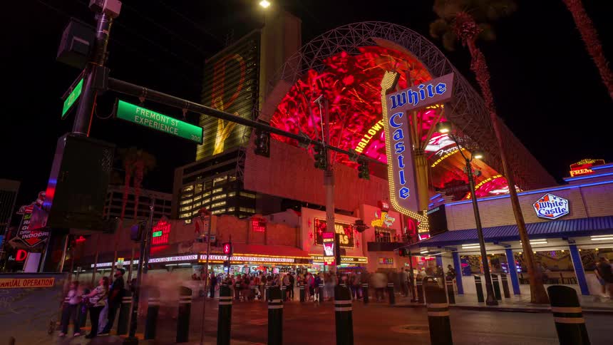 Pedestrians walk in the Fremont Street Experience in Las Vegas past the stores at night