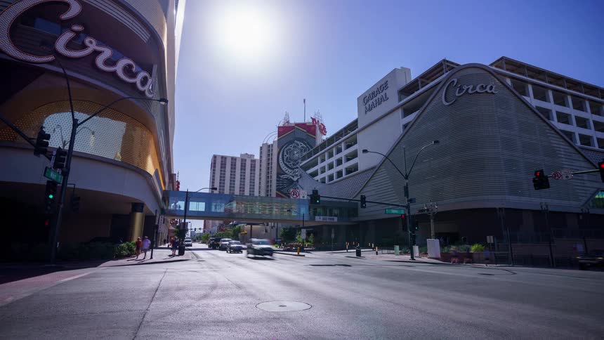A wide shot of a sunlit urban street with Circa Hotel buildings on both sides in downtown Las Vegas