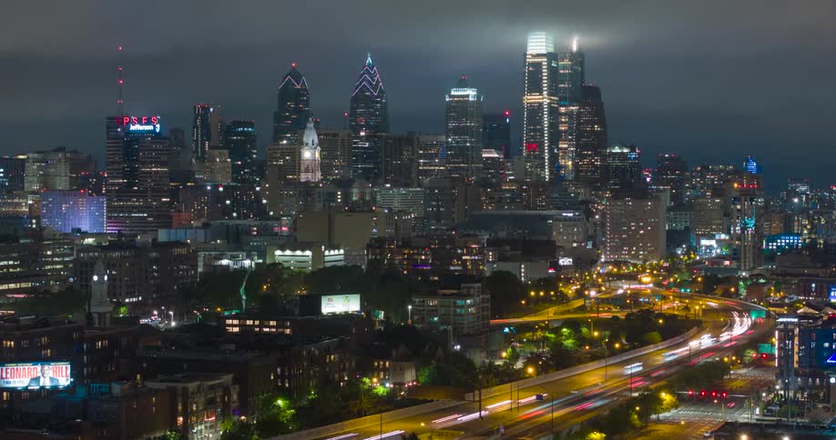 Vehicles are speeding through a highway in the middle of a downtown Center City Philadelphia