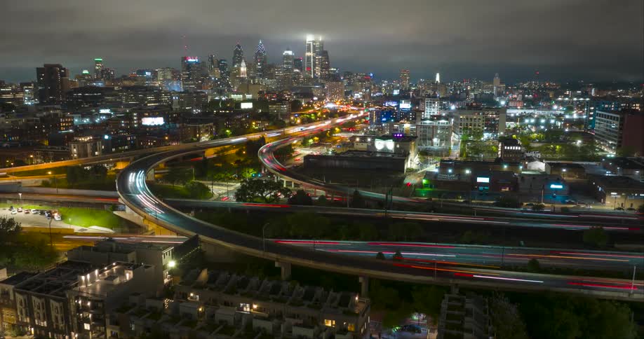 Aerial of the Philadelphia skyline with busy roads and overpasses at nighttime