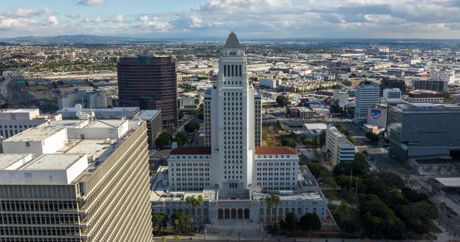 An aerial time lapse aerial view of cloud shadows moving over the Los Angeles City Hall on a sunny day