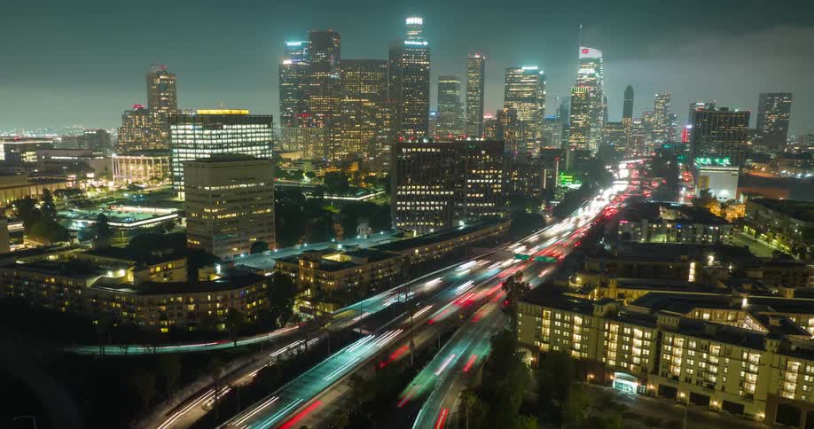 Aerial of a Los Angeles skyline with busy highways and overpasses at nigh