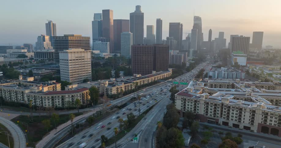 Aerial hyperlapse of downtown Los Angeles with busy roads and overpasses at sunset