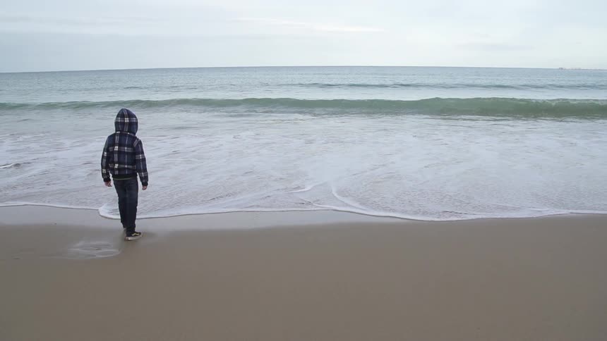 Child walking into the water at the beach