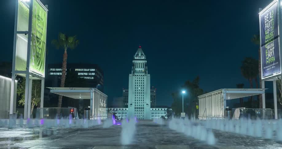 The large fountain shoots water up at night in Grand  Park and Los Angeles City Hall
