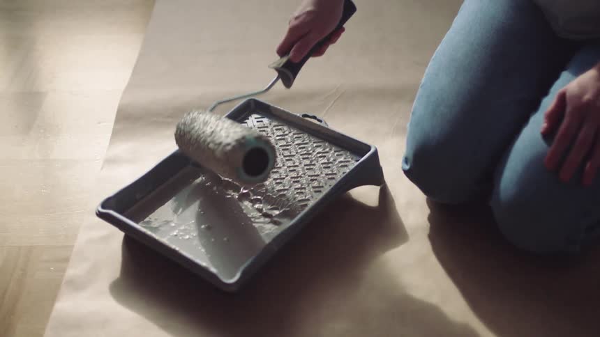 A female is sitting on the ground and mixing paint together