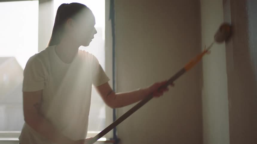 A woman is painting the walls in her house a different color
