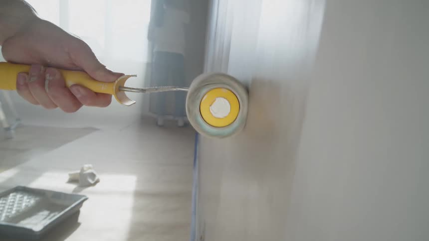 The roller goes up and down the wall with paint