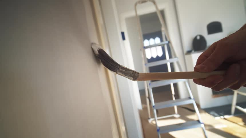 A person painting a wall with a brush