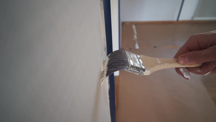 Point of view painting an interior wall with a hand brush