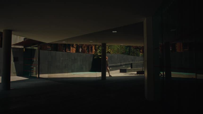 Large glass door reflecting a redheaded woman walking