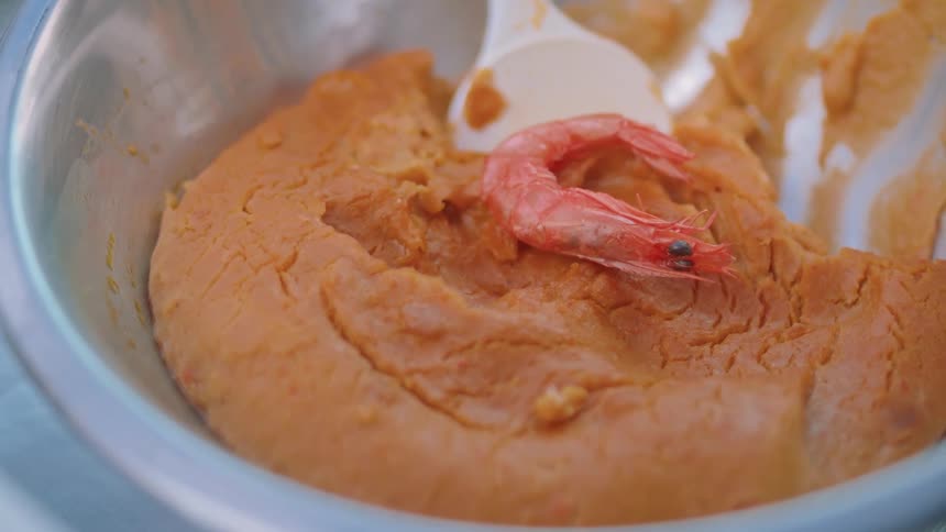 A bowl of food with a shrimp on top