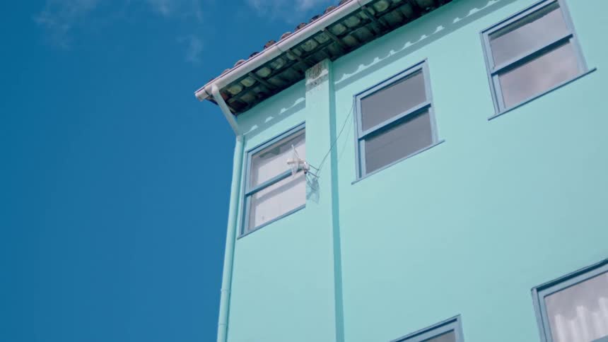 A light blue house against a dark blue sky