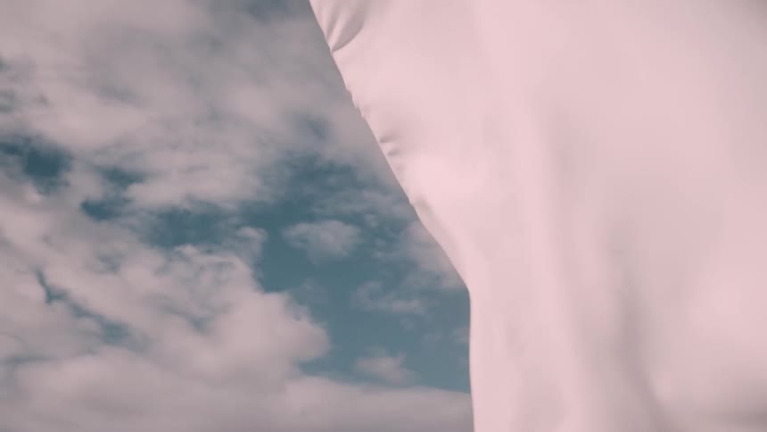A woman with a white cape billowing behind her