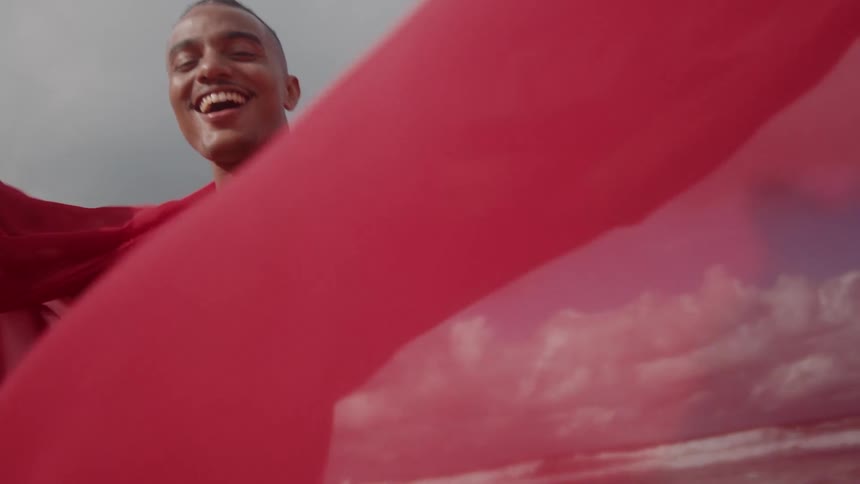 A man with a red cape billowing behind him