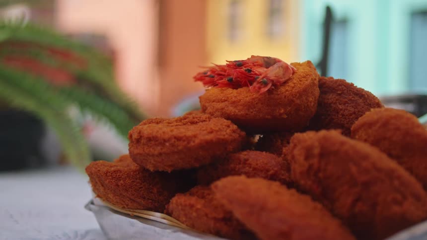 A plate of food is served in a bowl and placed on a table outdoors at midday