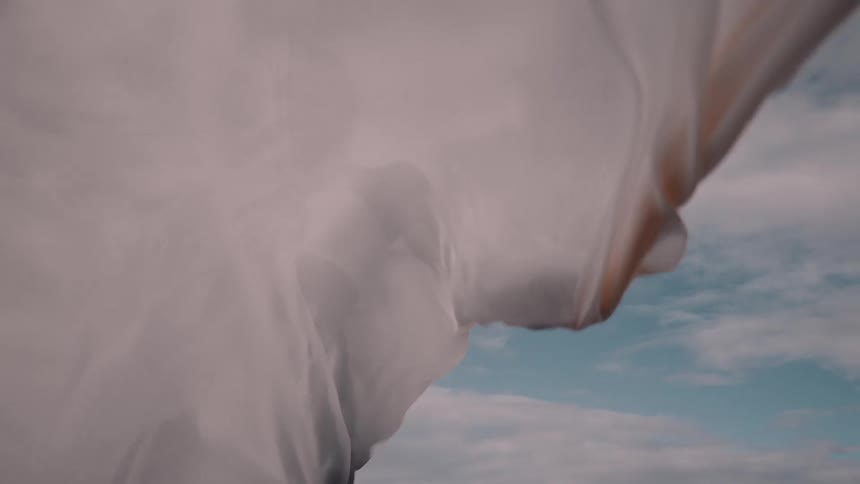 A woman with a white cape billowing around her