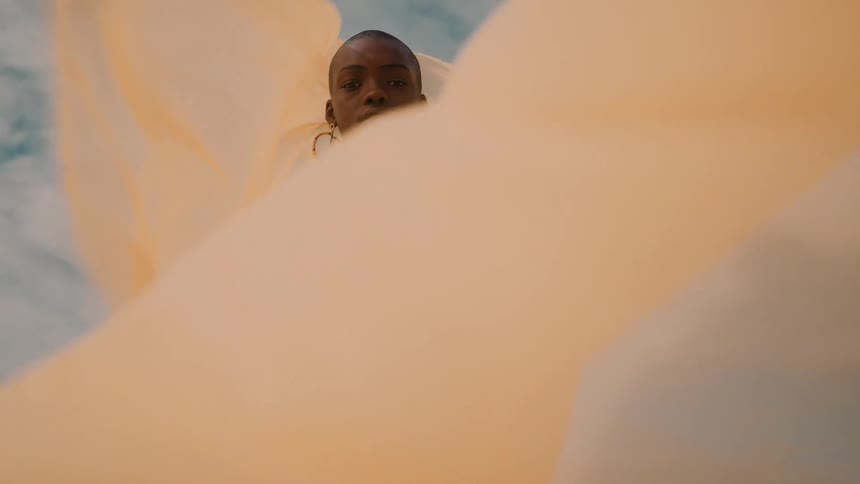 Wind blows the sheet the woman is holding