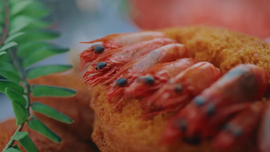 A breaded food topped with shrimp