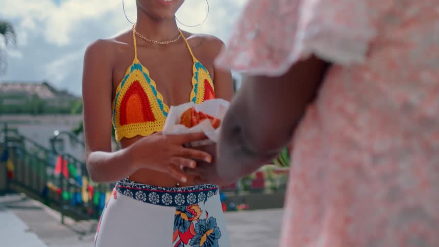 A woman is handing food outside