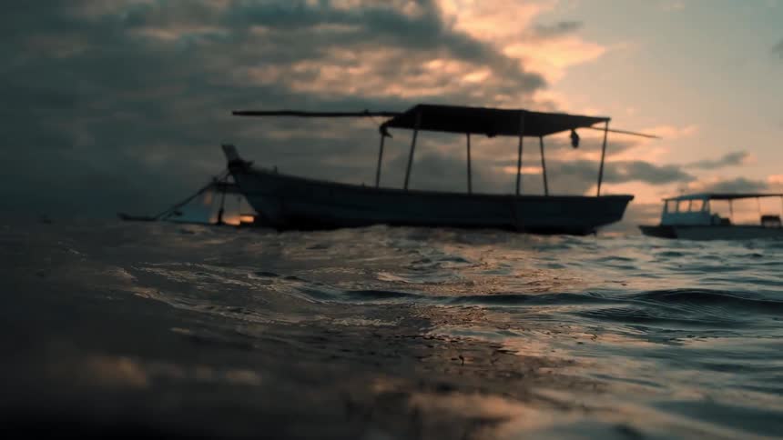 The boats float in the rough waters