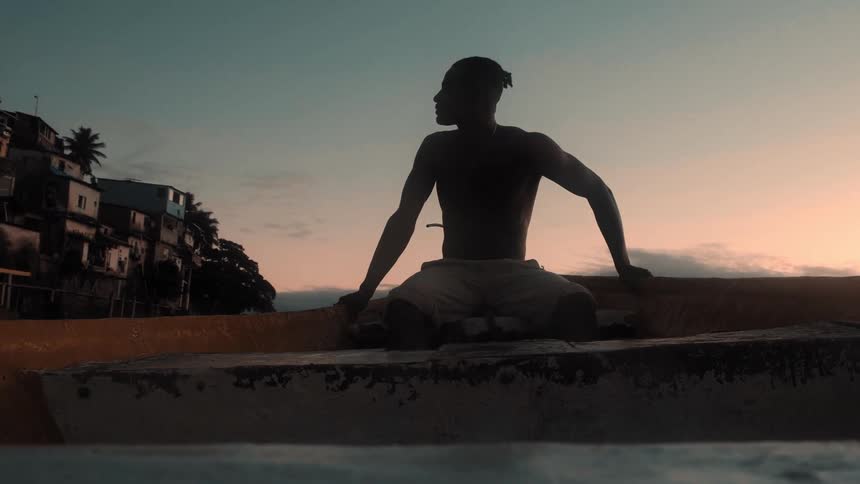 The man is watching the sunset on a rowboat