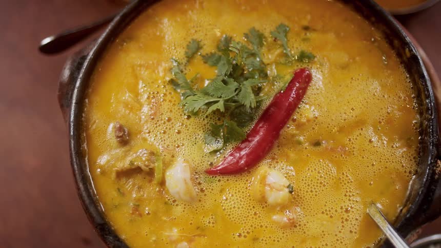 A soup recipe is being cooked in a cookware pot