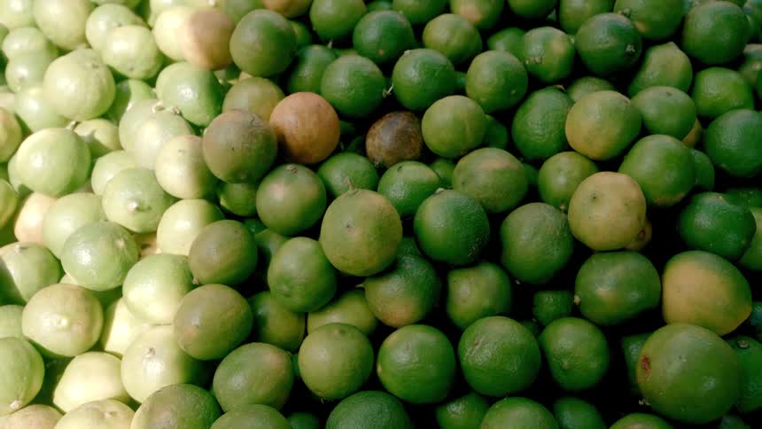 A large stack of limes is on the stand