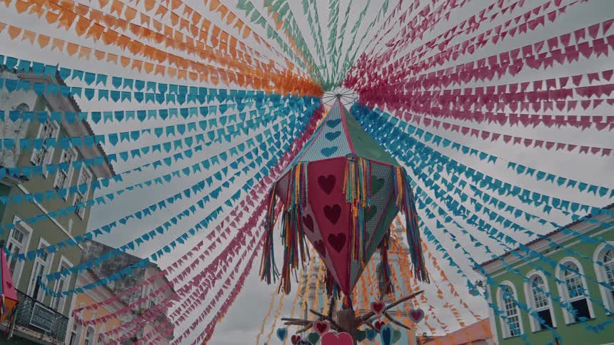 Colorful streamers and a heart lantern hang over a festive cultural street scene