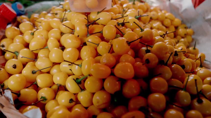 Yellow cherries inside a basket at daytime
