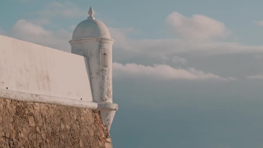 A white domed building is on the cliff
