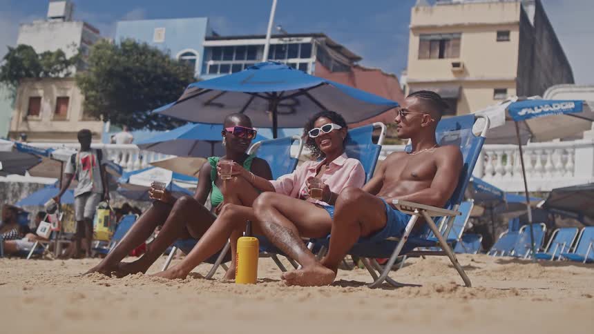Group of friends lounging on beach chairs enjoying drinks