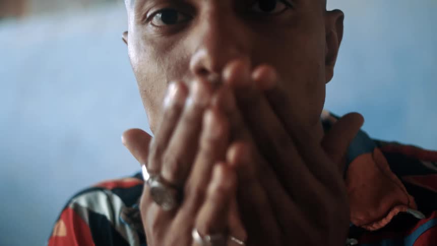 A man rubs his face and smiles