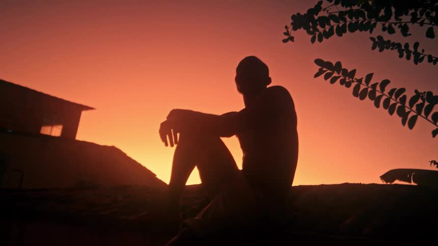 The man is watching the sunset by the villa