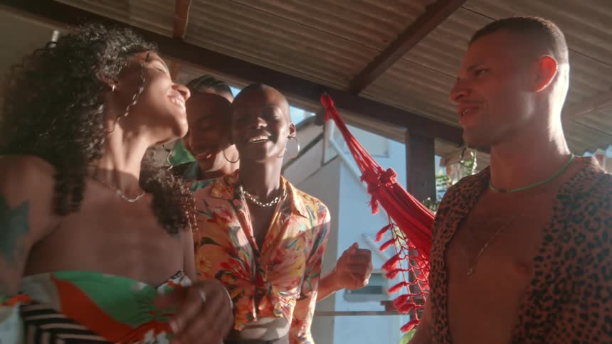 Friends enjoy dancing and laughing together on a sunny balcony