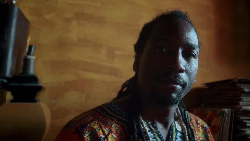 Close up portrait of a black man sitting in a room during daytime