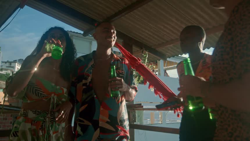 Friends relax and laugh together while drinking on a sunny patio