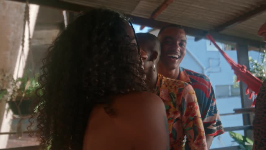A man and a woman are happy while they are hugging and in front of them there are their friends they are dancing